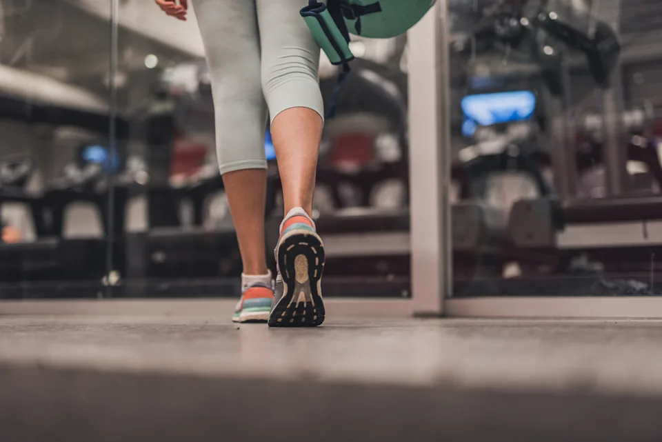 Close up of unknown woman whit a gym bag entering in training centre.